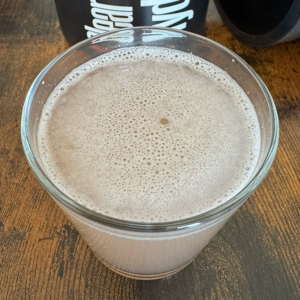Nahaufnahme des angerührten Clear-Whey-Hydrate-Shakes mit einer Schicht aus feinen Schaumbläschen